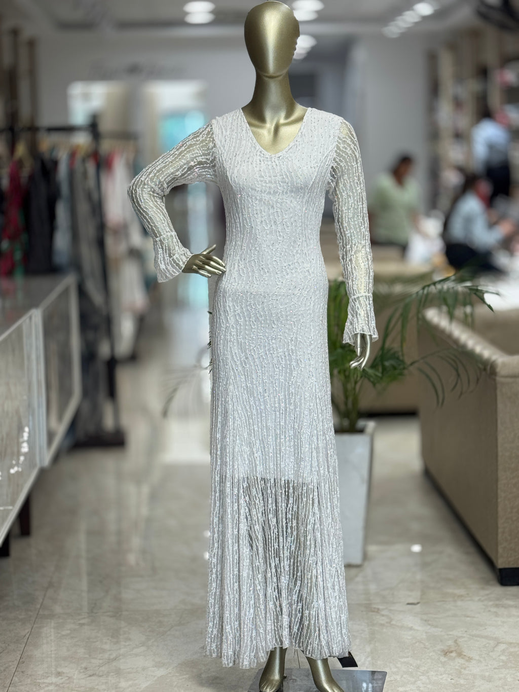 Q562312 Elegant white embellished gown with fringe detailing and statement sleeves.